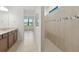 Modern bathroom featuring a tiled shower, neutral color scheme, and spacious vanity with generous counter space at 3065 Winding Creek Trl, North Port, FL 34289