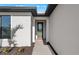 Welcoming front entrance with a decorative glass door, brick pathway, and well-maintained landscaping at 3065 Winding Creek Trl, North Port, FL 34289