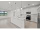 Open-concept kitchen featuring an island, stainless steel appliances, pendant lights, and tile flooring at 3065 Winding Creek Trl, North Port, FL 34289