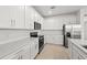 Modern kitchen with white cabinets, stainless steel appliances, ample countertop space, and sleek backsplash at 3065 Winding Creek Trl, North Port, FL 34289