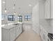 Spacious white kitchen with an island, stainless steel appliances, tile backsplash, and open layout at 3065 Winding Creek Trl, North Port, FL 34289