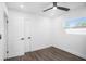 Bright bedroom with white walls, dark wood-look floors, and a ceiling fan at 4516 N Jamaica St, Tampa, FL 33614