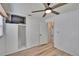 Bright bedroom features wood-look floors, ceiling fan, and closet with built-in TV shelf at 6524 14Th N St, St Petersburg, FL 33702