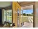 View from the home's interior out to the front yard, showcasing a bright yellow front door at 6524 14Th N St, St Petersburg, FL 33702