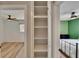 Hallway featuring a built-in shelf with views to two bedrooms with ceiling fans at 6524 14Th N St, St Petersburg, FL 33702