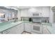 White kitchen with light green countertops at 7871 Sailboat Key S Blvd # 106, South Pasadena, FL 33707