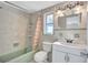 Bathroom with tub shower, white vanity, and tile floors at 8840 Cairo Ln, Port Richey, FL 34668