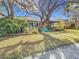 View of the home's exterior from the backyard, highlighting the screened porch and pergola at 16829 Midsummer Ln, Spring Hill, FL 34610