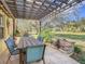 Charming backyard with a wooden pergola, dining table, and a built-in fire pit at 16829 Midsummer Ln, Spring Hill, FL 34610