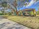 Exterior view of the home with a covered patio, screened enclosure, and lush green lawn at 16829 Midsummer Ln, Spring Hill, FL 34610