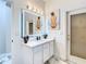Modern bathroom with white vanity, backlit mirror, and marble-look tile floor at 16829 Midsummer Ln, Spring Hill, FL 34610