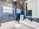 Modern bathroom with dark marble tile, white vanity, and glass-enclosed shower at 16829 Midsummer Ln, Spring Hill, FL 34610
