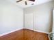 Spacious bedroom with hardwood floors, white closet, and ceiling fan at 16829 Midsummer Ln, Spring Hill, FL 34610