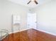 Bedroom with hardwood floors, ceiling fan, and open door leading to another room at 16829 Midsummer Ln, Spring Hill, FL 34610