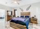 Bedroom with wooden accents, ceiling fan, marble-look tile, and ensuite access at 16829 Midsummer Ln, Spring Hill, FL 34610