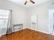 Bright bedroom with polished wood floors, a ceiling fan, and a small white cabinet at 16829 Midsummer Ln, Spring Hill, FL 34610