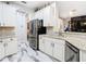 Updated kitchen with white cabinets, stainless steel appliances, and a stylish tiled floor at 16829 Midsummer Ln, Spring Hill, FL 34610