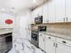 Well-appointed kitchen with white cabinetry, stainless steel appliances, and granite countertops at 16829 Midsummer Ln, Spring Hill, FL 34610