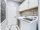 Laundry room with white cabinets, washer, dryer, and marble tile flooring at 16829 Midsummer Ln, Spring Hill, FL 34610