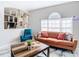 Stylish living room with a burnt orange couch, blue recliner, and built-in shelving at 16829 Midsummer Ln, Spring Hill, FL 34610