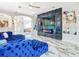 Luxurious living area with marble floors, electric fireplace, and plush blue sectional sofa at 16829 Midsummer Ln, Spring Hill, FL 34610