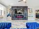 Modern living room with marble tile floors, a fireplace with a large TV, and blue sectional seating at 16829 Midsummer Ln, Spring Hill, FL 34610