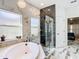 Luxurious Primary bath with soaking tub, glass shower, and marble tile at 16829 Midsummer Ln, Spring Hill, FL 34610