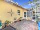 Spacious screened patio with brick flooring, potted plants, and access to the backyard at 16829 Midsummer Ln, Spring Hill, FL 34610