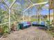 Screened patio with seating area, plants, and a brick floor at 16829 Midsummer Ln, Spring Hill, FL 34610
