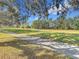 Paved walking path through a grassy area surrounded by trees at 16829 Midsummer Ln, Spring Hill, FL 34610