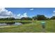 Disc golf basket on a lush green course next to a calm lake, providing a serene outdoor recreational activity at 1722 St Croix Dr, Clearwater, FL 33759
