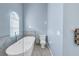 Updated bathroom featuring a soaking tub, toilet, and soft blue walls at 637 Pinellas Bayway S # 111, St Petersburg, FL 33715