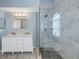 Bright bathroom with dual vanity, glass shower, and marble tile at 637 Pinellas Bayway S # 111, St Petersburg, FL 33715