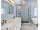 Modern bathroom with dual sinks, walk-in shower with pebble tile floor, and soaking tub at 637 Pinellas Bayway S # 111, St Petersburg, FL 33715