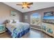 Bedroom with ceiling fan, large window, and wood-look flooring at 637 Pinellas Bayway S # 111, St Petersburg, FL 33715