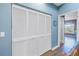 Hallway with white louvered closet doors and wood-look flooring at 637 Pinellas Bayway S # 111, St Petersburg, FL 33715