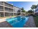 Inviting community pool surrounded by lush landscaping and condo buildings at 637 Pinellas Bayway S # 111, St Petersburg, FL 33715