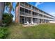 Exterior view of a waterfront property with patio seating at 637 Pinellas Bayway S # 111, St Petersburg, FL 33715
