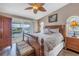 Spacious bedroom with wooden furniture, ceiling fan, and sliding door access to a balcony at 637 Pinellas Bayway S # 111, St Petersburg, FL 33715