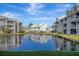 Pond view of condo buildings and lush green grass at 6923 Stonesthrow N Cir # 4105, St Petersburg, FL 33710