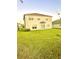 A spacious backyard featuring lush green grass and a sliding glass door at 7423 Pulteney Dr, Zephyrhills, FL 33545