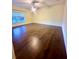 This bedroom is a spacious retreat with hardwood floors, ample natural light, and a ceiling fan at 7423 Pulteney Dr, Zephyrhills, FL 33545