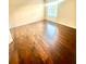 Bedroom featuring wood floors and bright natural light from the large window at 7423 Pulteney Dr, Zephyrhills, FL 33545