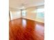 Spacious bedroom with ceiling fan, hardwood floors, and windows offering ample natural light at 7423 Pulteney Dr, Zephyrhills, FL 33545