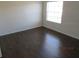 Bright bedroom with dark brown wood flooring and large window at 7423 Pulteney Dr, Zephyrhills, FL 33545