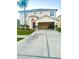 Two-story home features a spacious driveway, attached garage, manicured lawn, and a charming purple front door at 7423 Pulteney Dr, Zephyrhills, FL 33545