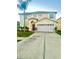 Charming two-story home with a well-manicured lawn, a two-car garage, and a beautiful palm tree at 7423 Pulteney Dr, Zephyrhills, FL 33545