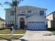 Two-story house with a two-car garage and landscaped lawn at 7423 Pulteney Dr, Zephyrhills, FL 33545