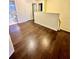 Bright hallway featuring beautiful hardwood floors, fresh paint, and doorways to bedrooms and bathrooms at 7423 Pulteney Dr, Zephyrhills, FL 33545