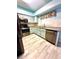 Well-lit kitchen with stainless steel appliances, granite countertops, and light blue cabinetry at 7423 Pulteney Dr, Zephyrhills, FL 33545